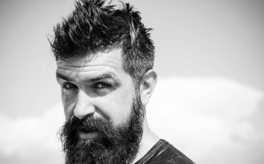 Sakallı adam için modaya uygun saç modeli. Uzun sakallı ve traşsız adam şık saç kesimi ile. Güneşli gökyüzü arka plan üzerinde sakallı adam. Sakallı yüzünde ıslak sakallı ve bıyıklı saçlı vahşi kafkas hipster