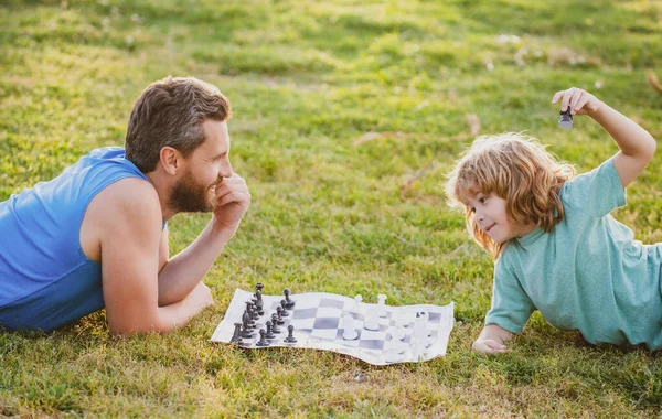 Padre e hijo jugando ajedrez pasando tiempo juntos en el parque. — Foto de Stock