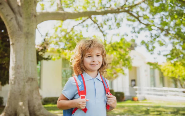 Kind mit Rucksack steht im Park in der Nähe der Schule. Schüler mit Büchern und Rucksäcken im Freien. Bildungskonzept für Kinder. — Stockfoto