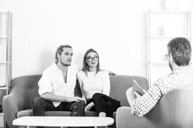 Sosyal Hizmetler psikoloğu genç bir çiftle konuşuyor. Aile psikoloji oturumunda.