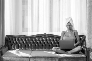 Pijamalı, güzel, şehvetli bir kadın. Laptop kullanıyor. Evde, yatak odasında keyfine bakıyor..