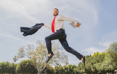 Heyecanlı iş adamı hızlı koşuyor, yarışıyor ve zıplıyor. Başarılı bir iş adamının portresi. Gülümseyerek koşan harika bir adam..