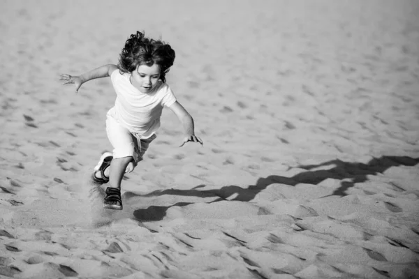 Niño jugar con arena en la playa. Chico activo divirtiéndose en vacaciones de verano. —  Fotos de Stock