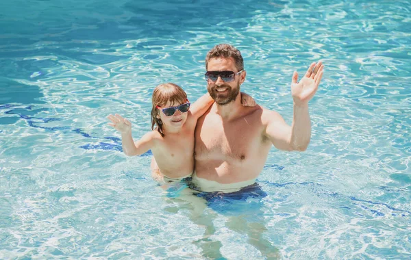 Vader en zoon zwemmen in het zwembad, zomerfamilie. Kind met papa die in het zwembad speelt. Aquapark. Vader en zoon vrije tijd. — Stockfoto