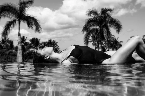 Mulher desfrutando de férias na praia de luxo no resort do hotel com piscina e paisagem tropical perto da praia do mar. — Fotografia de Stock