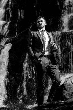 Başarılı modern iş adamı. Kariyer üstü. Şelale arka planında takım elbiseli yakışıklı bir iş adamı..