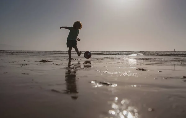 Kodは夏休みにビーチでサッカーやサッカー、日没のシルエットを再生します。. — ストック写真