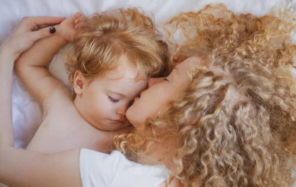 Giovane madre e bambino vanno a letto insieme. Sogni e bambini dormono. — Foto Stock