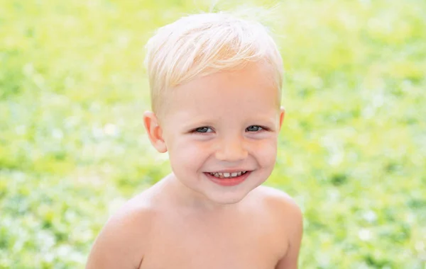 Um retrato infantil feliz. Engraçado. Menino feliz em pé na grama no dia ensolarado de verão. Feliz dia.. — Fotografia de Stock