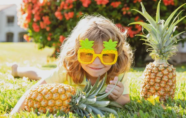 Criança divertida sorridente com abacaxis óculos de sol ao ar livre. Um miúdo de verão. Rapaz em estilo abacaxi louco. Engraçado cara de crianças verão. — Fotografia de Stock