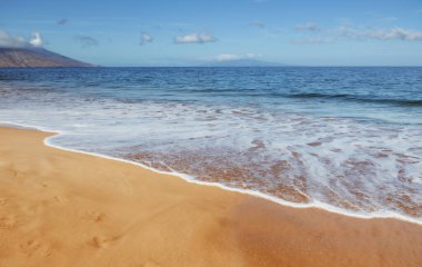 Kumlu sahilde mavi okyanus dalgası. Yaz mevsiminde gün batımında plaj. Plaj manzarası. Tropik deniz manzarası, sakinlik, dinlendirici güneş ışığı.