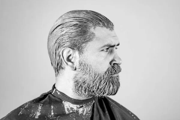 Retrato de coloração de cabelo homem. Um hipster barbudo. Processo de um homem com sua cor de cabelo no salão de cabeleireiro. — Fotografia de Stock