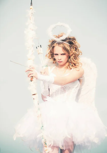 Saint Valentin. Ange enfant fille aux cheveux blonds bouclés. Charmante petite fille bouclée en robe blanche et ailes ange fille Cupidon. Ange fille avec halo en robe d'ange blanche — Photo