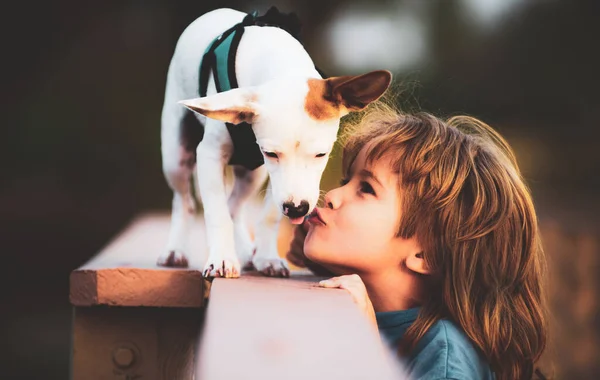 Portret kind jongen kus puppi hond. Vriend huisdier. Grappige foto van gelukkig kind knuffelen mooie puppy hond. — Stockfoto