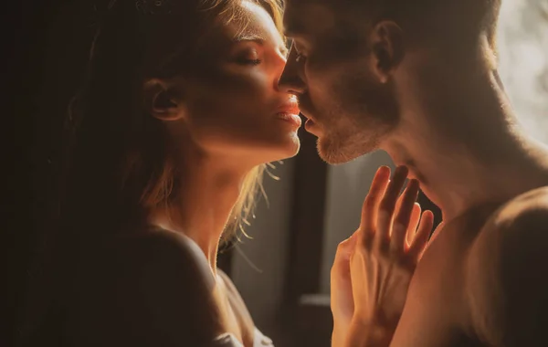 Portrait of lovely couple in love. Young sensual girlfriend glad to passionate kiss from her boyfriend. Handsome man embraces his woman and kisses. Sensual couple in the tender passion. — Stock Photo, Image