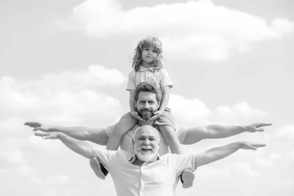 Grandfather with son and grandson raising hands or open arms flying. Multi Generation Family. Fathers day.