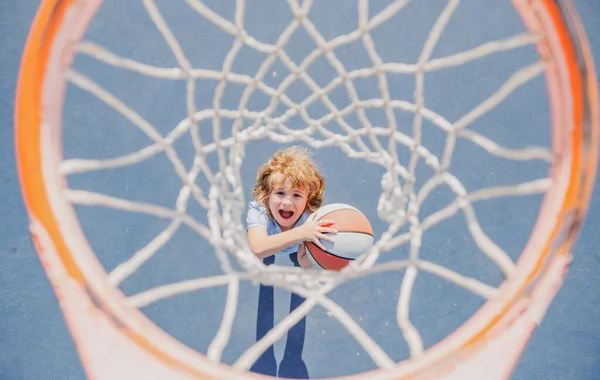 Vista superior del niño emocionado jugando baloncesto sosteniendo la pelota con la cara feliz. — Foto de Stock