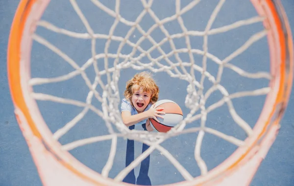 Visão superior da criança animada jogando basquete segurando bola com rosto feliz. — Fotografia de Stock