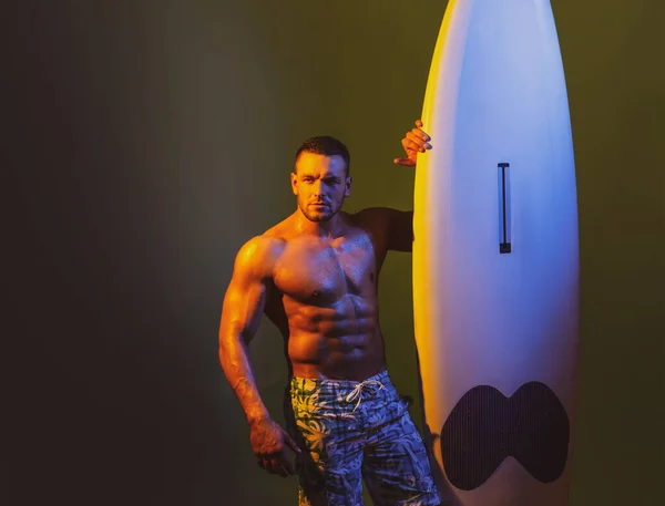 Surfplank man met lijfplank. Surfer met een surfplank. Sexy man nat over lichaam houden lijfplank met rechterhand, tonen fit en gespierd lichaam, model poseren. — Stockfoto