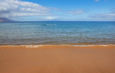 Plaj geçmişi. Kumlu sahilde sakin, güzel bir okyanus dalgası. Tropikal deniz manzarası.