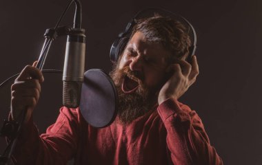 Mikrofonlu adam şarkı söylüyor. Müzikholdeki müzisyen. Karaoke yaparken komik adam şarkı söylüyor..