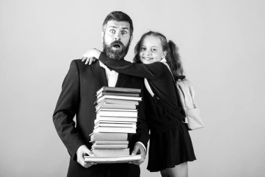 Stüdyoda ilköğretim öğrencisi kucaklaşması öğretmeni. Baba ya da öğretmen ve liseli kız büyük yığınlar halinde okul kitaplarına sahipler. Öğretmenler Günü.