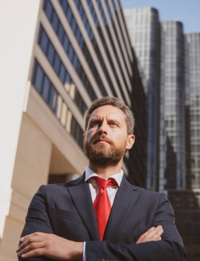 Girişimci, iş portresi. İş adamı dışarıda kolları bağlı gururla duruyor..