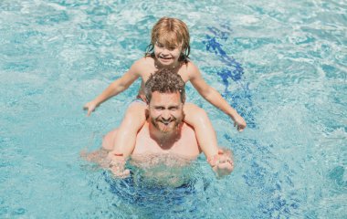 Baba oğul havuzda. Yüzme havuzunda bir aile. Yaz tatili. Babasıyla yüzme havuzunda yüzen bir çocuk. Etkin yaşam tarzı kavramı.