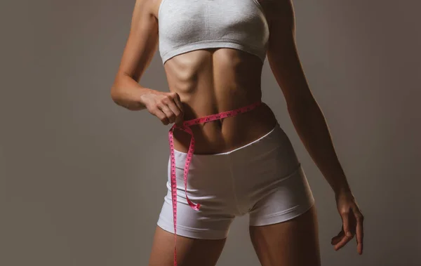Frauentaille mit Klebeband, Gewichtsverlust. Weibliches Modell Körperpflege. Frau misst Taille. — Stockfoto