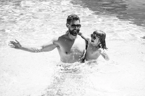 Apa és fia úszás medencében, nyári családi hét. — Stock Fotó