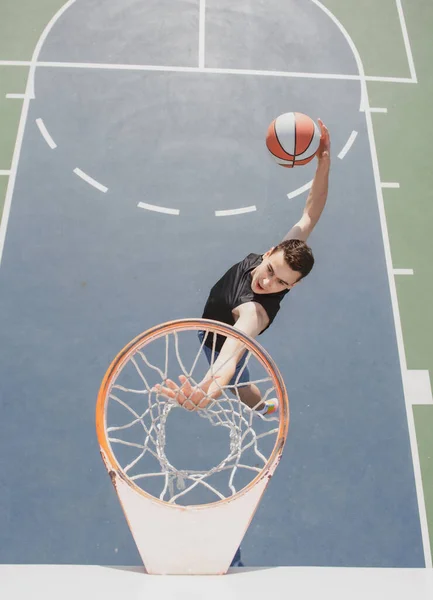 Jugador de baloncesto americano anotando un slam dunk. — Foto de Stock