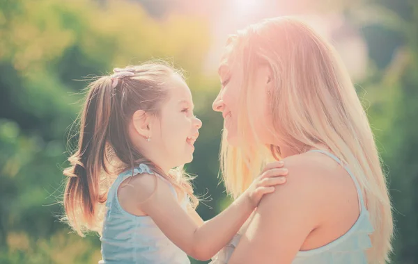 Kinderliebe. Nahaufnahme Porträt einer lächelnden Mutter, die ihre kleine Tochter umarmt. Familien- und Mutterschaftskonzept. Glückliche Frau und kleine Tochter lächeln. — Stockfoto