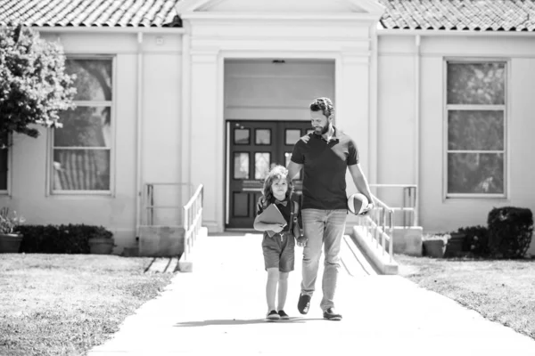 Padres y alumnos de primaria. Profesor y lindo colegial con mochila cerca del parque escolar. — Foto de Stock