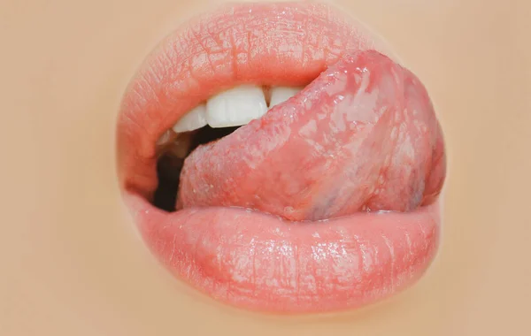 Skönhet mun uttryck koncept. Närbild av kvinnans ansikte med rött läppstift som slickar läpparna med sensuell tunga. — Stockfoto