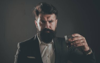 Şık zengin adam eski viski bir bardak tutan. Şık zarif sakallı adam Barmen viski cam tutar.