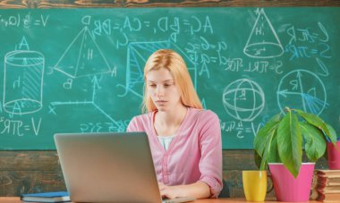 Kız öğrenci dizüstü bilgisayar kullanıyor. Okulda genç bir öğretmen ya da özel öğretmen. Kadın eğitimi.