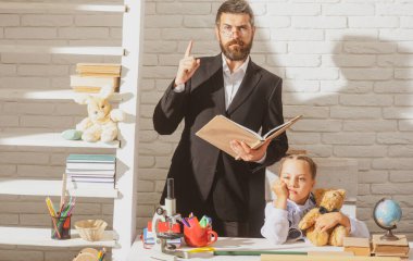 İlkokulda üzgün, küçük bir öğrenci kızla ciddi bir öğretmen. Babalar ve kızları öğreniyor. Babamla ödev yapıyorduk. Babası mutsuz, üzgün, küçük kızını destekliyor..