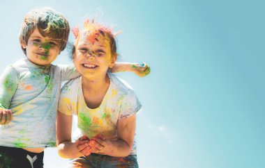Yüzü renklerle kaplı iki çocuk.