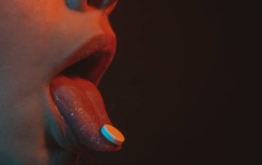 Kadın dilinde hapın yakın çekimi. Dil hapları açık ağızda tutar. Ağrı konseptini, günlük takviyeleri ya da antibiyotik antidepresanları ağıza vermek için ilaç alan hasta kadına yaklaşın..