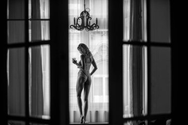 Yatak odasında panoramik pencereli güzel kadınlar. Evde ya da otel odasında yatakta tasasız kadın modeller. Sabah serinliği.