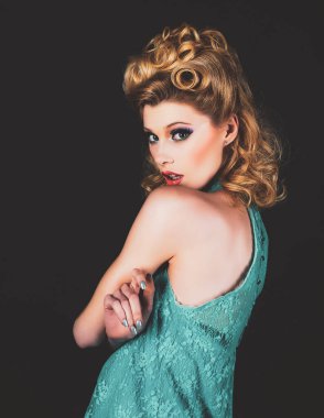 Retro tarzında güzel, genç bir Amerikalı kız, afiş. Eskimiş moda ve klasik konsept stüdyo çekimleriyle poz veren beyaz sarışın manken. Yüz ifadeleri.