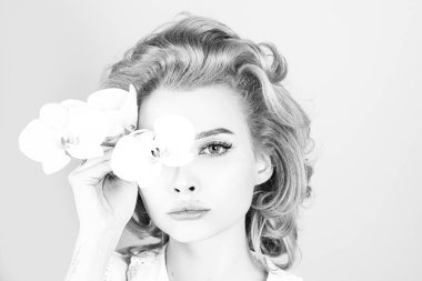 Güzel yüzlü kadın, yüz portresi. Kozmetik ve güzellik konsepti. Orkide çiçekli kadın..