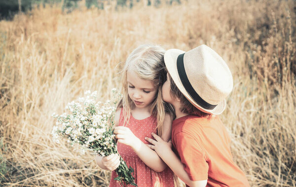 Summer portrait of happy cute children. Happy Valentines day. Kid having fun in spring field. Childhood on countryside. Romantic and love. Love concept