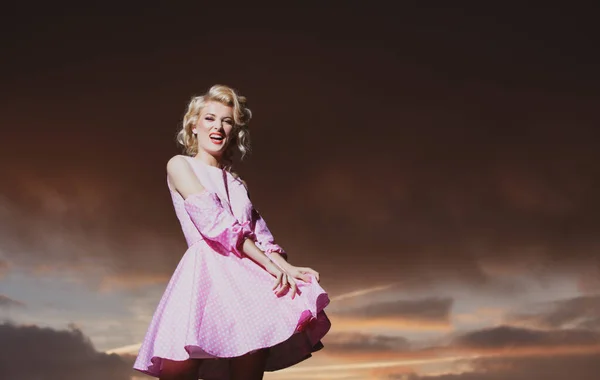 Kobieta w sukience Monroe na dramatycznym niebie. Atrakcyjna kobieta w stroju mody na zewnątrz. Outdoor moda zdjęcie młodej pięknej pani korzystających wiosną. — Zdjęcie stockowe