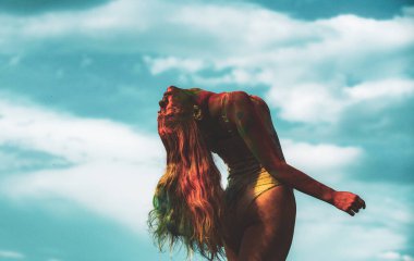 Vücuduna renkli bir vadi sıçramış. Holi boya partisindeki neşeli genç kadın..