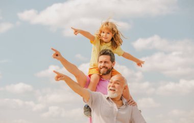 Baba ve oğul büyükbabayı işaret ettiği için çok heyecanlıydılar. El işaretleri noktası. Mutlu jenerasyon dilsiz üç nesil erkek aile portresi.