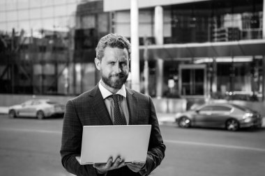 Dışarıda defter tutan bir iş adamı. Kendine güvenen bir iş uzmanı. Ofis geçmişinde dizüstü bilgisayarı olan yakışıklı bir adam..