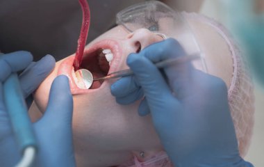 Yakın çekim dişçi klinikte bir kadın hastaya portresi. Her türlü ofiste diş hastalıkları tedavi etmek için özel ekipman vardır.