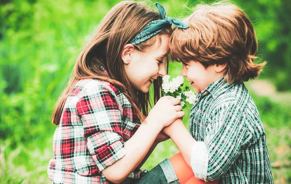 子供の愛の概念。バレンタインデーの本当の歴史。バレンタインカード。公園でタンポポの種を一緒に吹いている小さな友人. — ストック写真