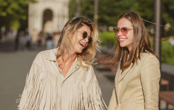 Dos mujeres felices y emocionadas caminando juntas en la calle. Mujer modelo de alta moda sorprendida posando en la calle de la ciudad. Feliz ocio, fin de semana sin preocupaciones y vacaciones románticas. —  Fotos de Stock